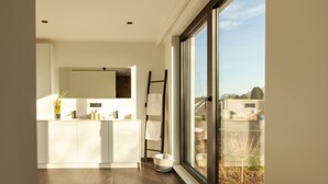 Una cocina moderna con un amplio ventanal, suelo de madera y vistas a la ciudad.
