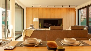Una sala de estar moderna con un juego de sofá, una chimenea y un comedor con una mesa preparada para dos.
