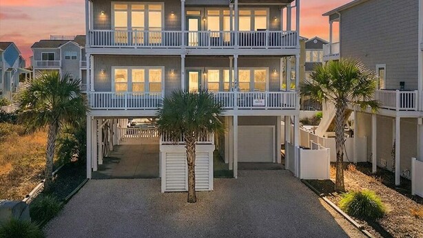 A two-story beachfront house with a covered patio and a garage. - Sea Esta is a 7-bedroom, 5-bathroom, large enough for the whole family! (Ocean Isle Beach)