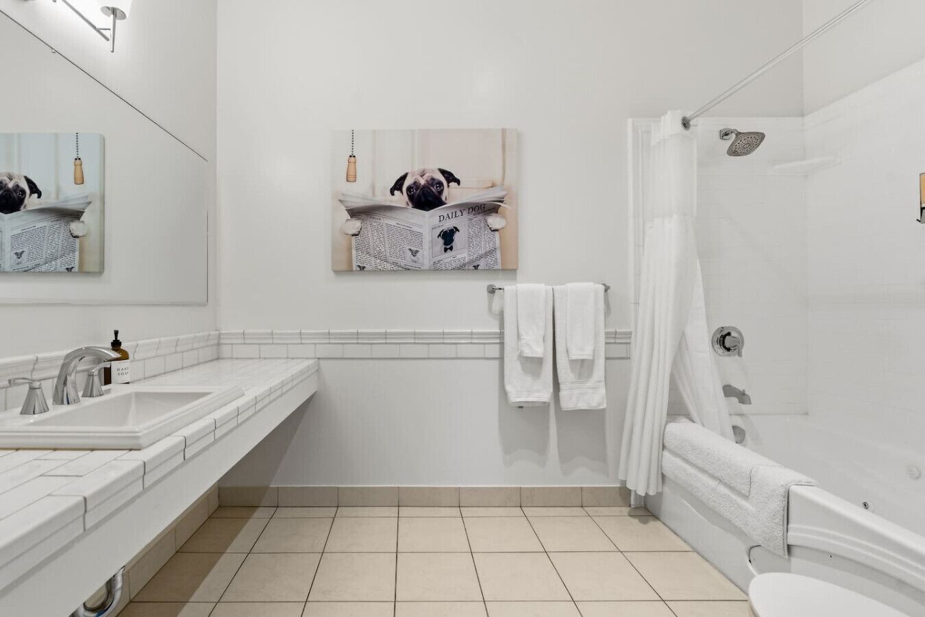 A modern bathroom with a large mirror, a sink, a shower, and a toilet.