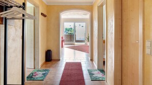 A hallway with a red carpet, a door with a glass panel, and a view to the outside. - Holiday Home 'Sport Rees - 7 Fewo Eventraum' with Mountain View, Private Terrace & Wi-Fi (Oberried)