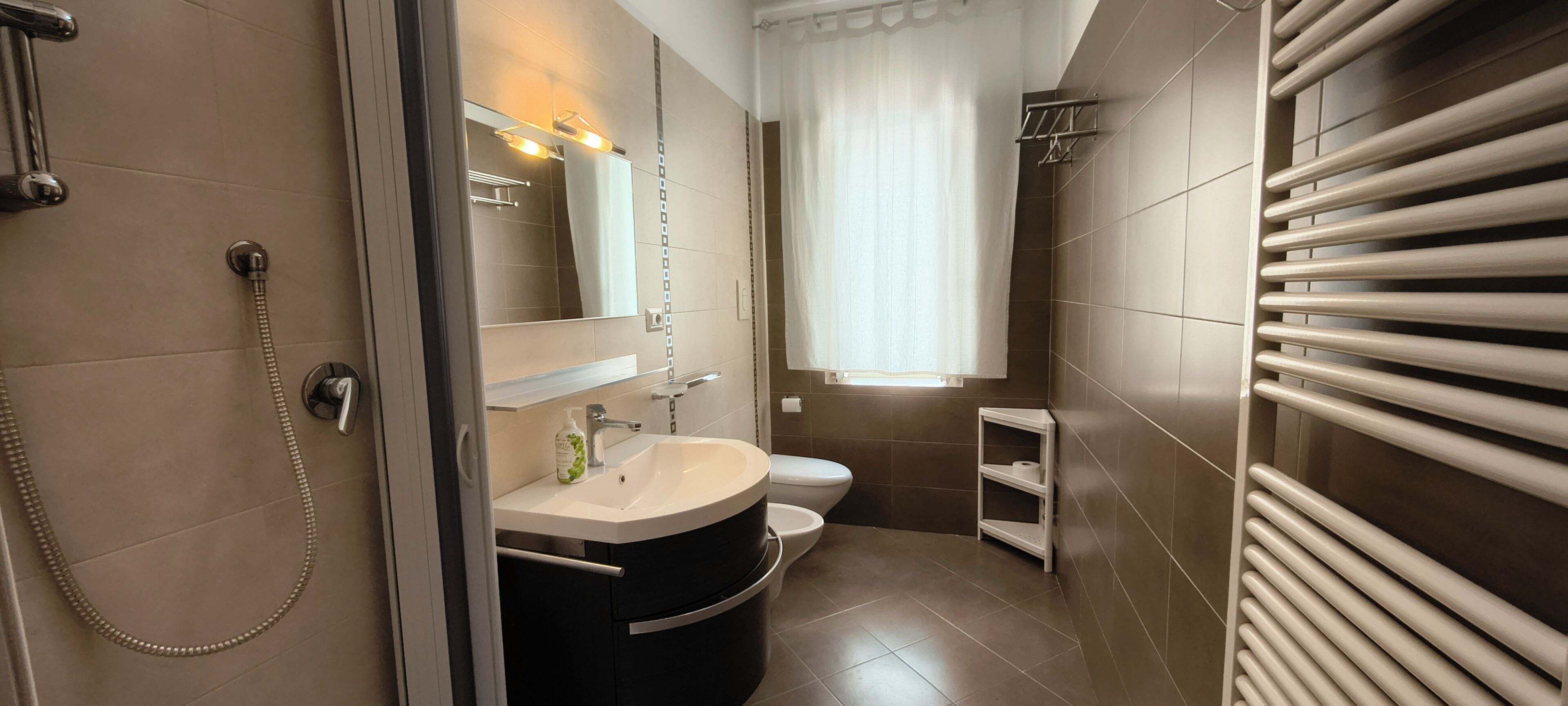 A modern bathroom with a toilet, sink, and shower.