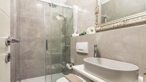 A modern bathroom with a glass-enclosed shower, a white sink, and a large mirror. - Villa Chiara Opatija Apartment Moderna (Ičići)