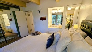 Una camera da letto con un letto grande, una finestra vista, uno specchio e una porta.
