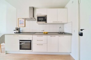 Een microgolfoven, een oven, een kookplaat, een vaatwasser