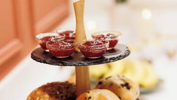 A multi-tiered serving tray with various baked goods and jams.