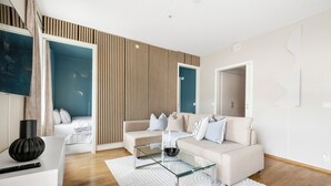 A modern living room with a glass coffee table, a beige sofa, and a white rug.