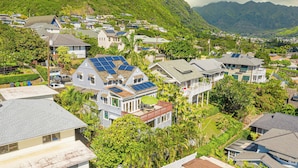 A residential area with houses featuring solar panels, surrounded by lush greenery and hills. - Hale Ho‘omalie- Peaceful Mānoa Valley Retreat near UH (Honolulu)