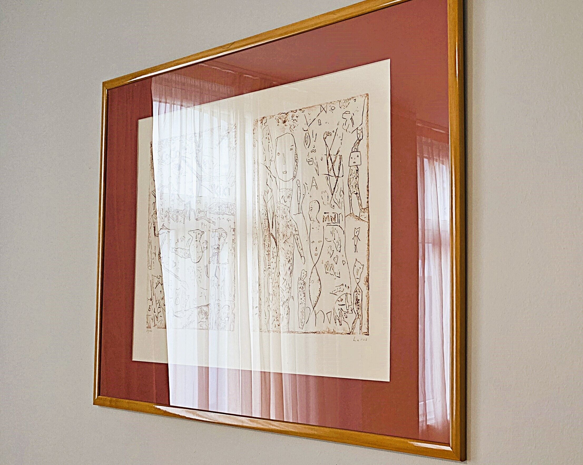 Een lijst met abstracte schetsen aan de muur.