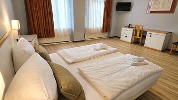 Ett hotellrum med en säng, sängbord, ett skrivbord, en stol och en tv.