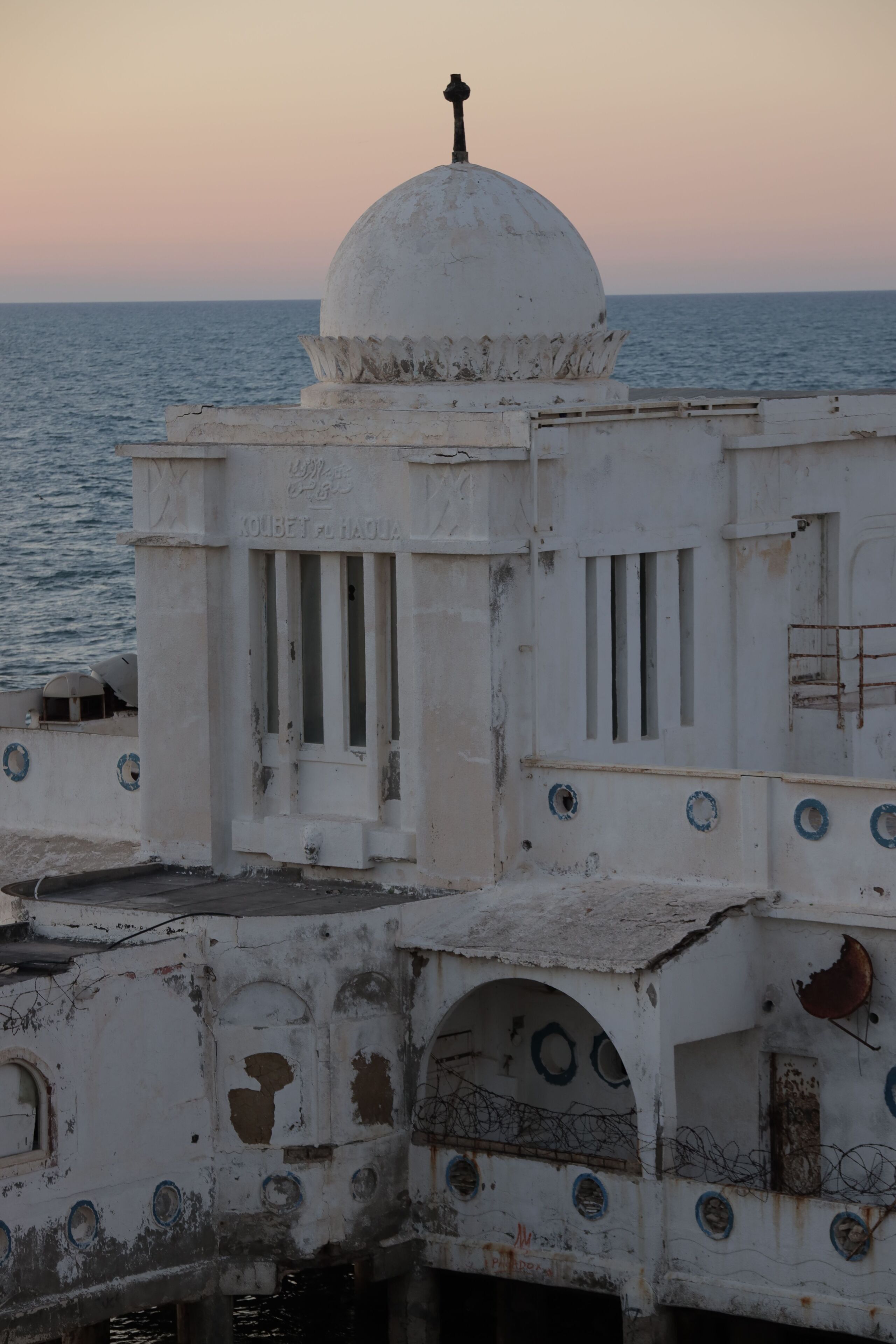 Un bâtiment blanc surmonté d’un dôme et d’une croix, qui domine la mer.