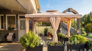 A covered outdoor seating area with potted plants, a chair, and a sign indicating a price of 75€. - Studio apartment Flora by Villas Guide (Pula)
