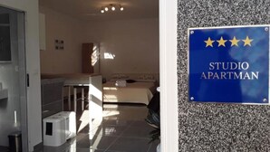 A hotel room with a bed, a desk, and a bathroom. There is a sign on the wall that reads 'STUDIO APARTMAN'. - Studio apartment Flora by Villas Guide (Pula)