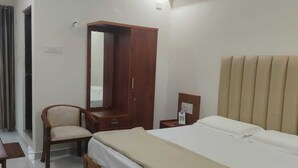 Un dormitorio con cama, muebles de madera, un armario, escritorio y una silla.