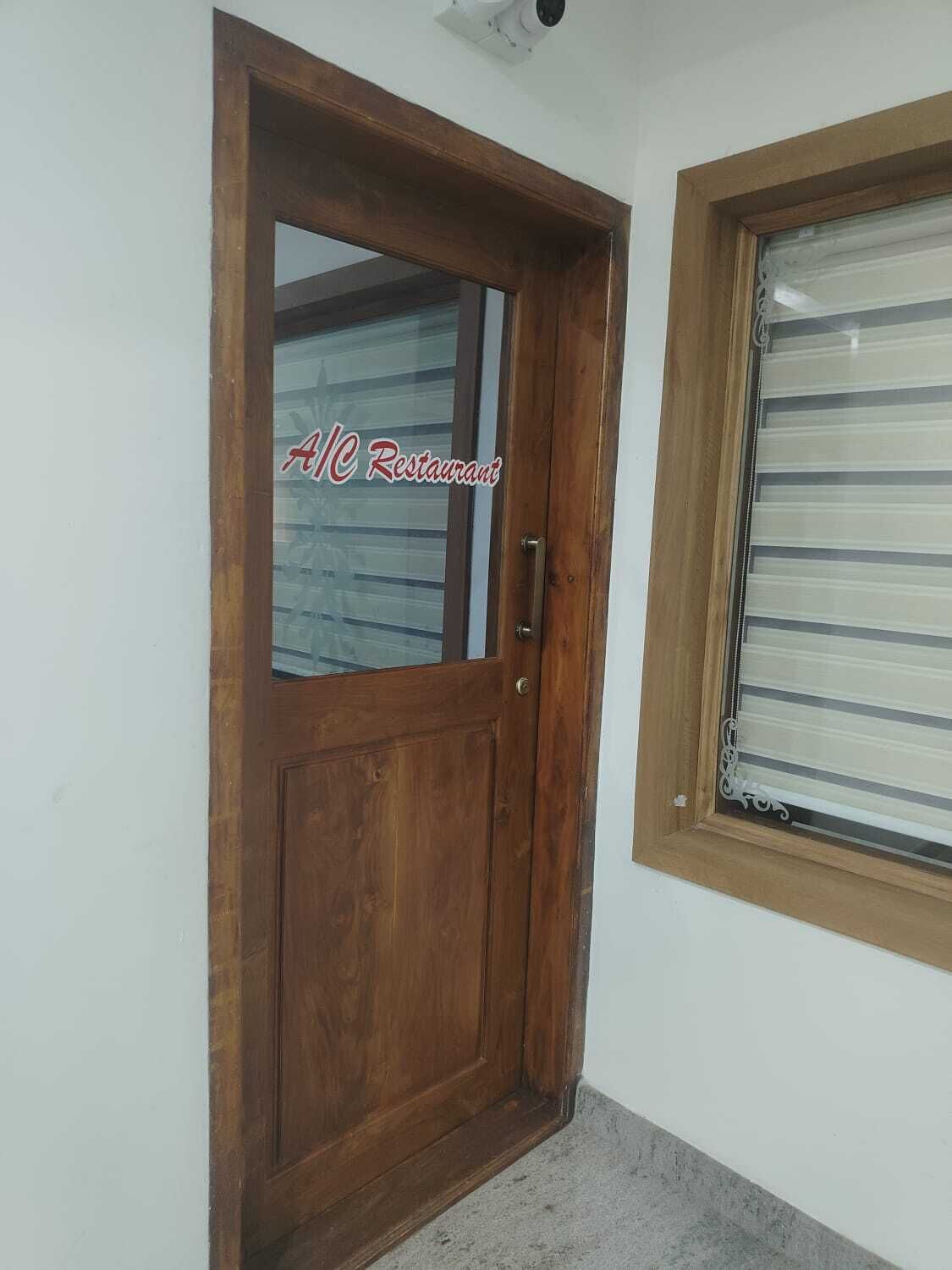 Eine Holztür mit Fensterglas und ein Fenster mit horizontalen Jalousien.