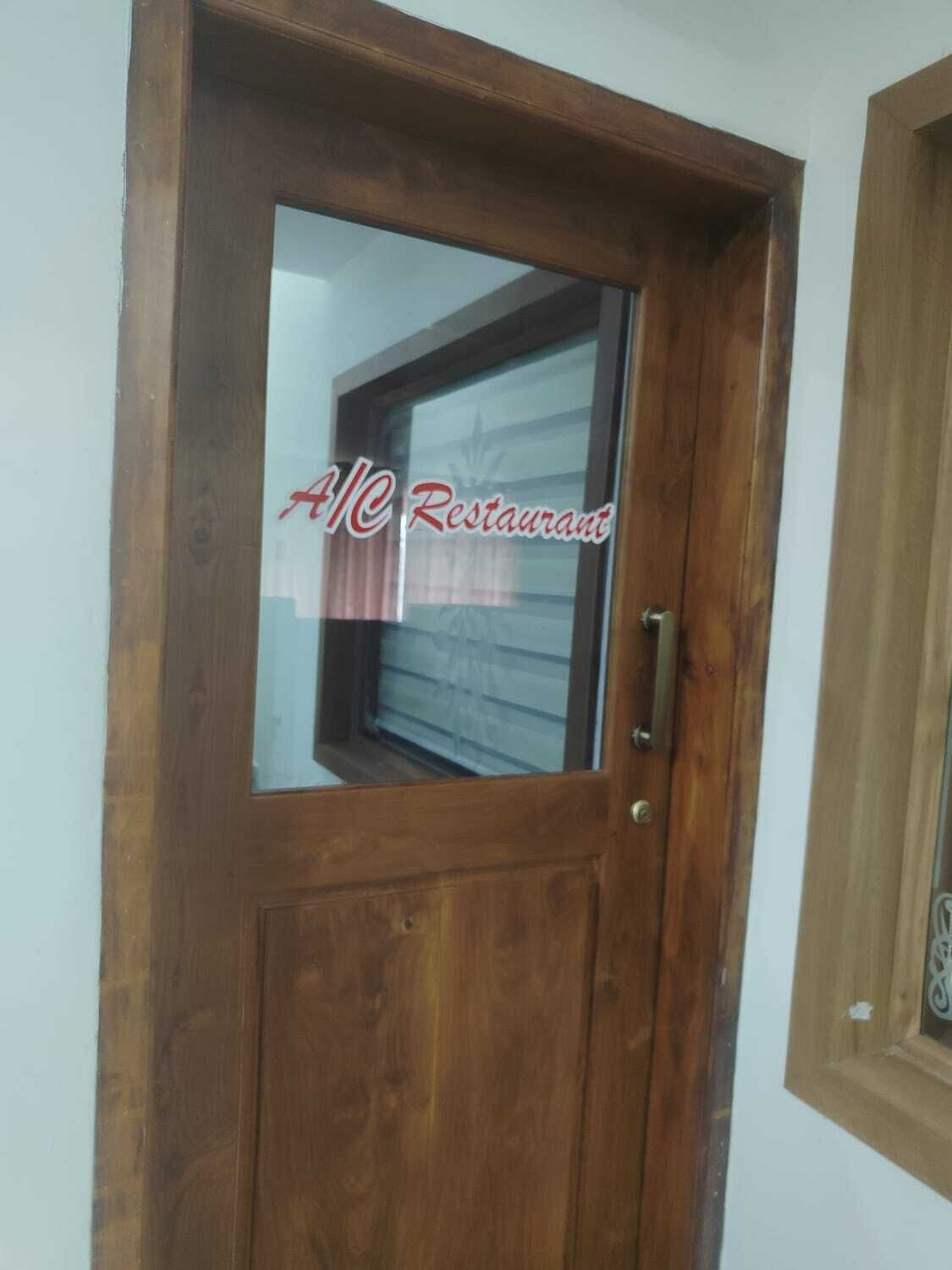 A wooden door with a glass panel and a handle.