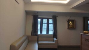 Una sala de estar moderna con un sofá, un ventilador de techo y un cuadro en la pared.
