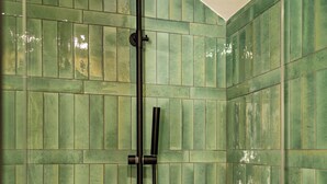 Een douche met een handdouche en een bedieningspaneel aan de muur.