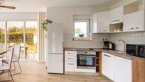 Eine moderne Küche mit Einbauofen, Geschirrspüler und einem Fenster über der Spüle.
