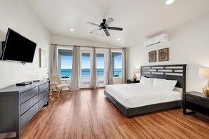 A bedroom with a bed, a desk, a chair, a TV, and a ceiling fan. - Gulf-Front Duplex | Pet Friendly | Shared Pool (Gulf Shores)