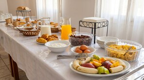 A breakfast buffet with various food items and beverages. - Lume D'oro Syros (Kini)