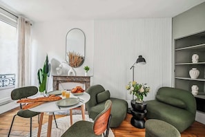Ein modernes Wohnzimmer mit Essbereich, Kamin und großem Spiegel.