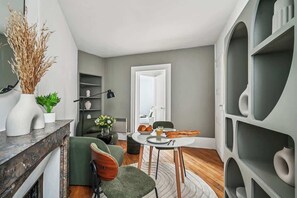 Ein modernes Wohnzimmer mit Essbereich, Kamin und großem Fenster.
