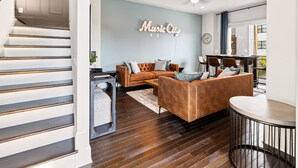Una sala de estar moderna con un sofá, una mesa de centro y un letrero en la pared que dice "Music City".