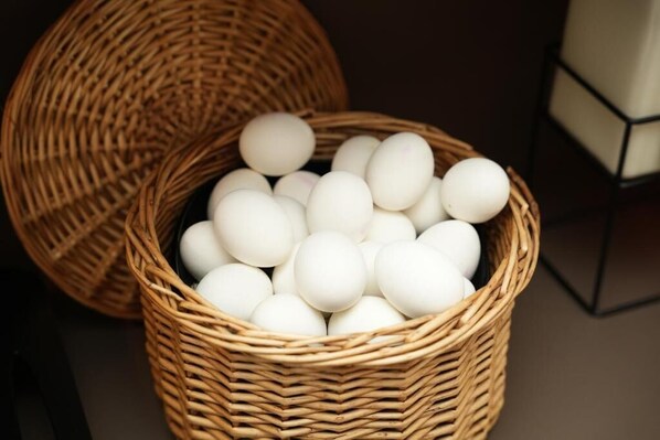 Un panier en osier rempli d’œufs blancs.