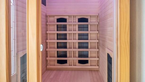Un sauna avec des murs et des bancs en bois.