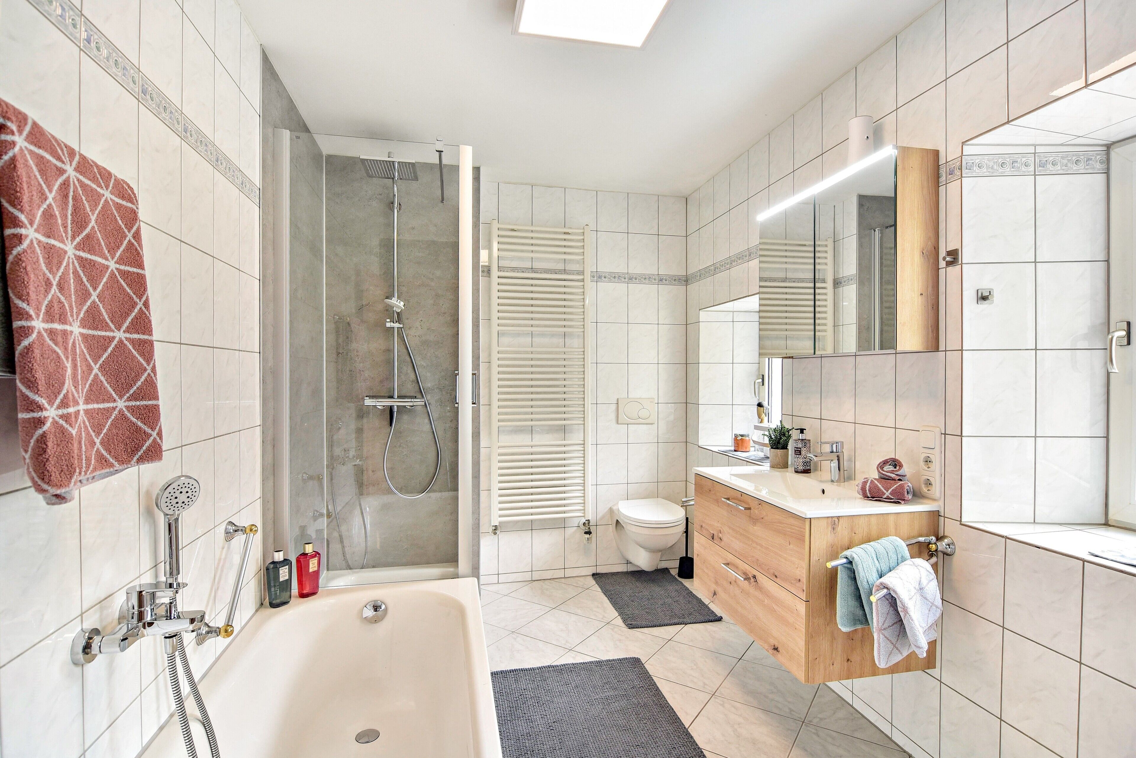 Un baño moderno con bañera, ducha, inodoro y tocador.