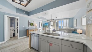 A modern kitchen with a large island, built-in appliances, and a view to the outside. - Shores 1613-King Bed-Beachfront Resort & Amenities (Panama City Beach)