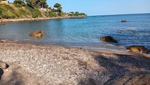 A rocky beach with clear water, a few trees, and a distant shoreline. - Villa Alisea in Cefalù, garden, pool and sea (Cefalù)