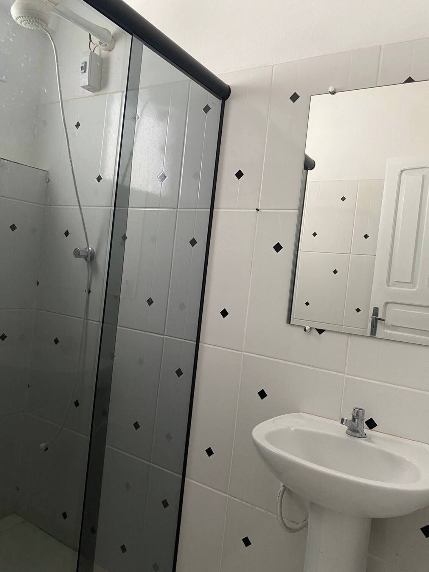 Une salle de bain avec une douche à parois de verre, un lavabo et un miroir.