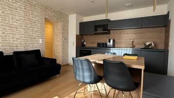 Eine moderne Küche mit dunklen Schränken, einer Holz Arbeitsplatte und einer eingebauten Mikrowelle.