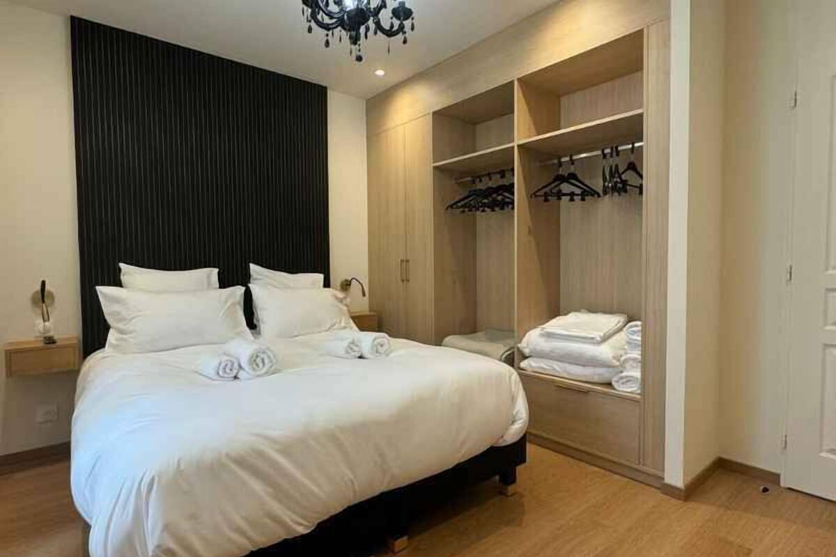 A bedroom with a large bed, a wardrobe, and a hanging closet.