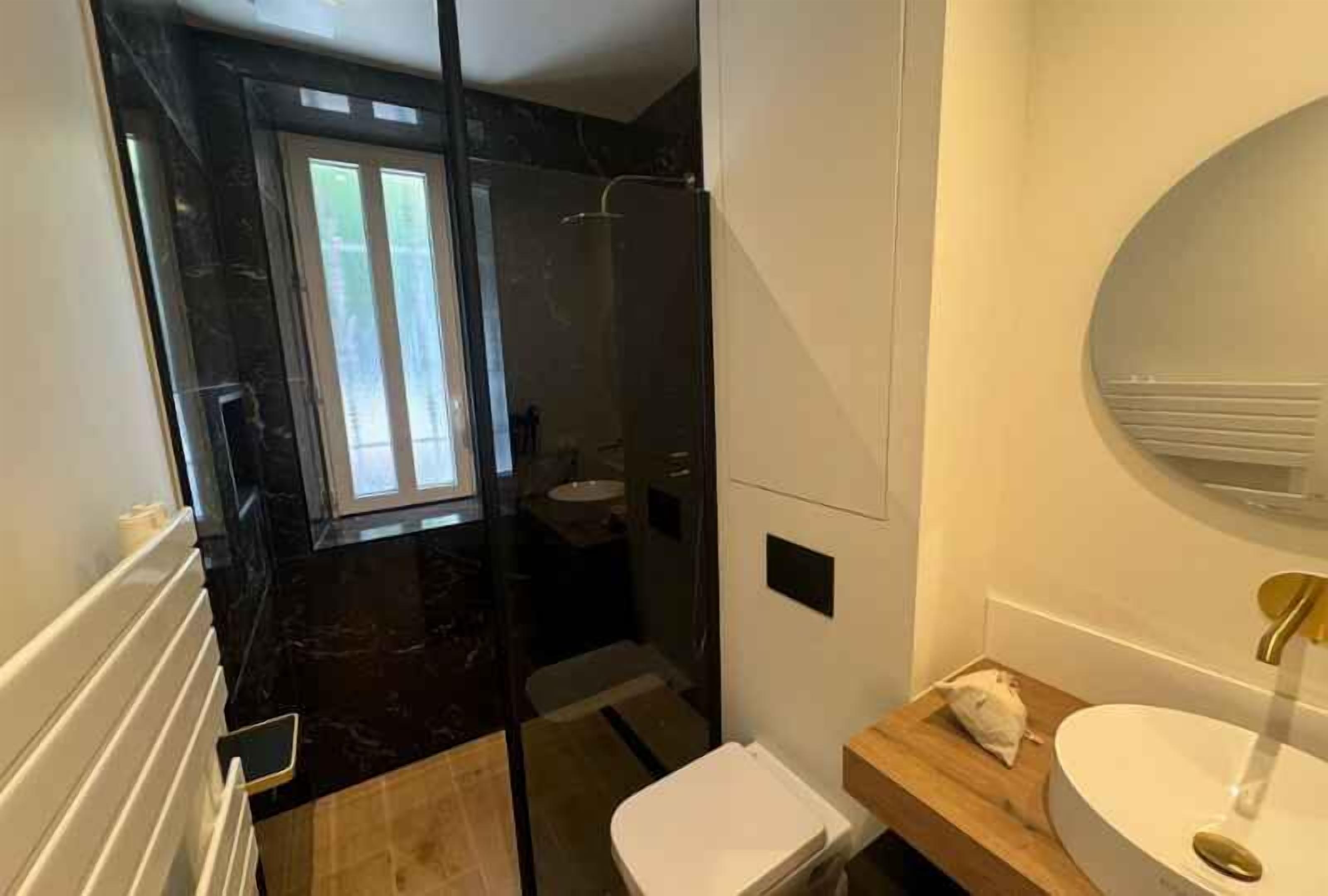 Une salle de bain équipée d’une douche, de toilettes, d’un lavabo et d’un miroir.