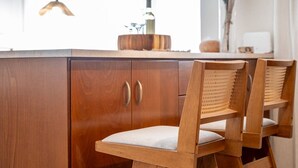 A wooden dining area with a cabinet and two chairs. - Veliero Blu | Kos Marina (Kos)