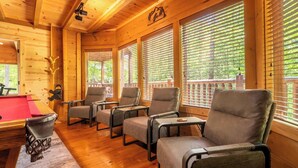 A wooden cabin with a pool table, four armchairs, and large windows. - Scenic 3BD | Outdoor Kitchen & Fireplace | Hot Tub (Sevierville)