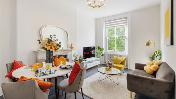 Un salon moderne comprenant un coin repas, un canapé, une table basse et un téléviseur.