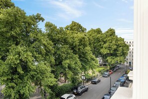 Eine Straße mit parkenden Autos und Bäumen.