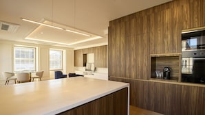 Une cuisine moderne avec des meubles en bois, un îlot central et des appareils électroménagers intégrés.