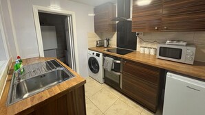 Cocina compacta con lavadora, microondas y refrigerador.