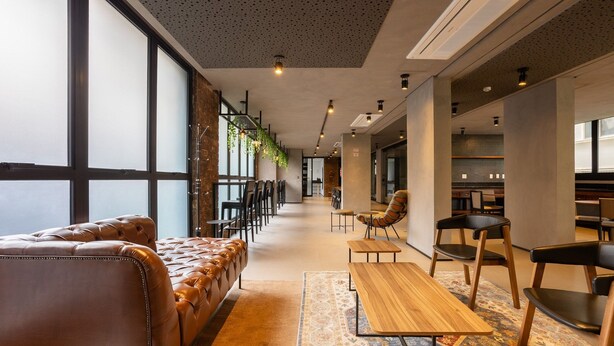A modern interior with leather seating, wooden tables, and a patterned rug. - Comfort and Convenience w/ an Unbeatable Location in Jardim Paulista - Onns (São Paulo)