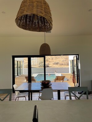 A modern interior with a dining area overlooking a pool and outdoor seating. - Fabulous 4-bedroom estate with guesthouse, pool, and AC in charming Yucca (Yucca)