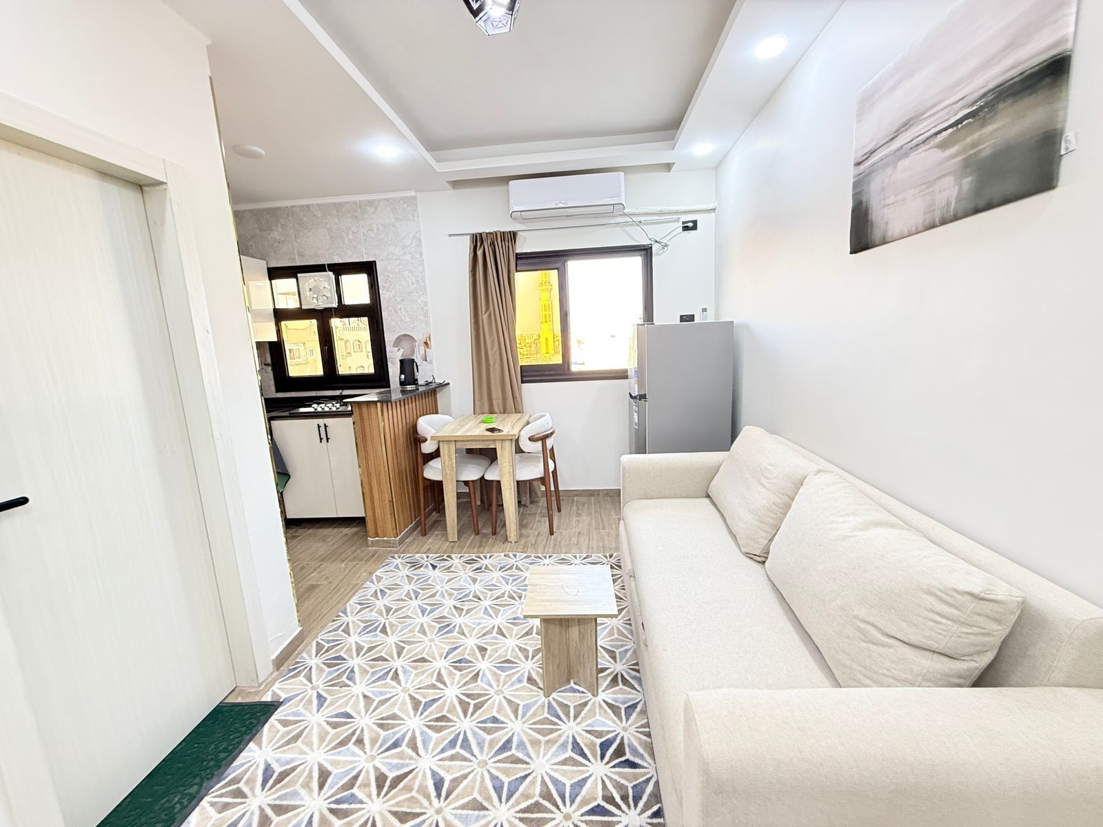 Un espacio habitable compacto con kitchenette, comedor y sofá.
