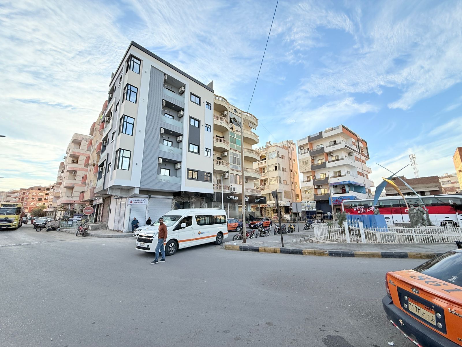 A multi-story building with a modern design, featuring balconies and large windows.