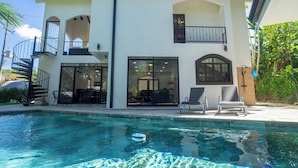 A two-story house with a swimming pool, outdoor seating, and a balcony. - Casa 78- Bright Modern Pool House with Deck (Esterillos Oeste)