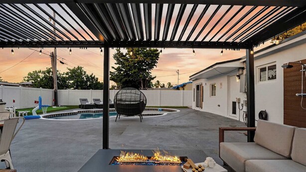 A covered patio with a fire feature, outdoor seating, and a pool. - Private Pool, Giant Chess, Golf, Games  by Ventur (Hollywood)