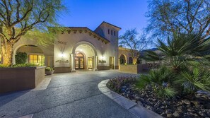 A building with a number '9002' on the facade, arched entryways, and a landscaped entrance area with rocks and plants. - Coachella Bound? Sleeps 4 at Marriott Shadow Ridge Resort (Palm Desert)